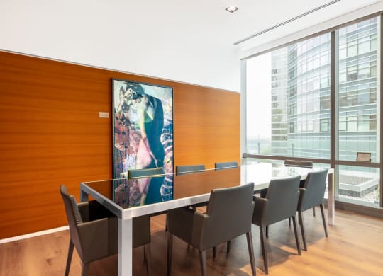 a conference room with a table and chairs and a painting on the wall