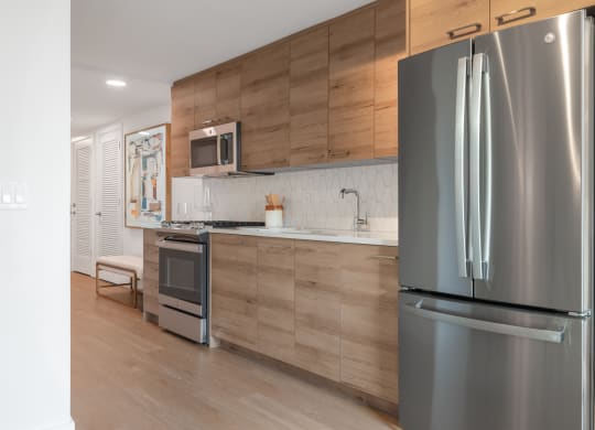 a kitchen with stainless steel appliances and wooden cabinets at The Grace and Reva, Virginia