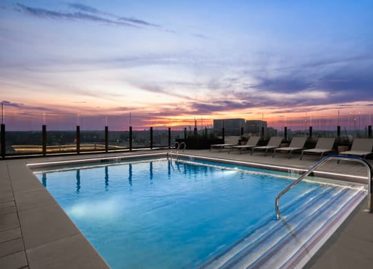 a swimming pool on the rooftop of a building at sunset at The Grace and Reva, Arlington, VA, 22202