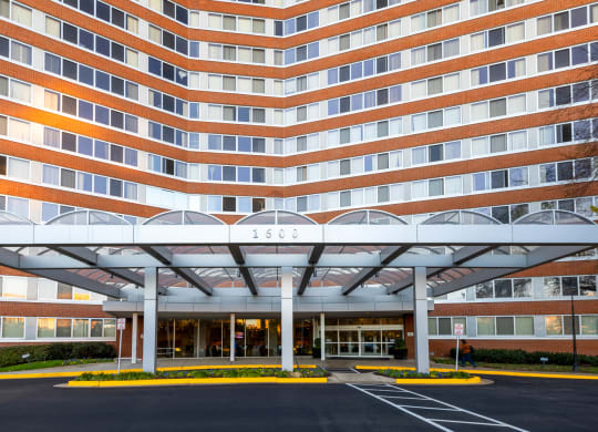 a large building with a covered entrance and a parking lot