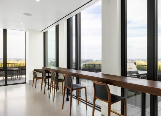 a long wooden table with chairs in a room with large windows  at The Grace and Reva, Arlington, Virginia