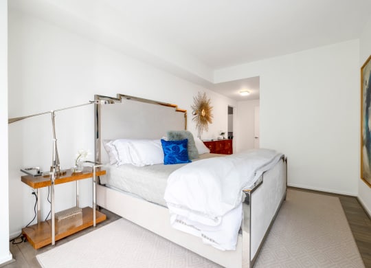 a white bedroom with a bed and a nightstand
