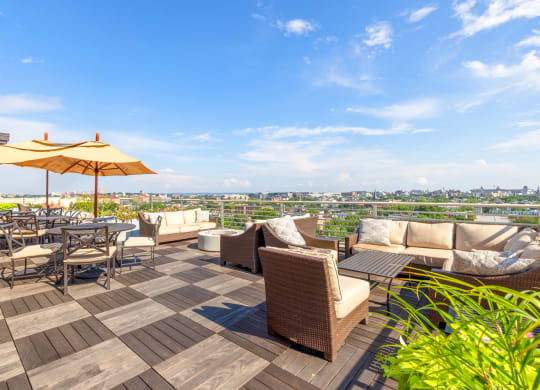 an outdoor patio with couches and tables with umbrellas and a view of the city