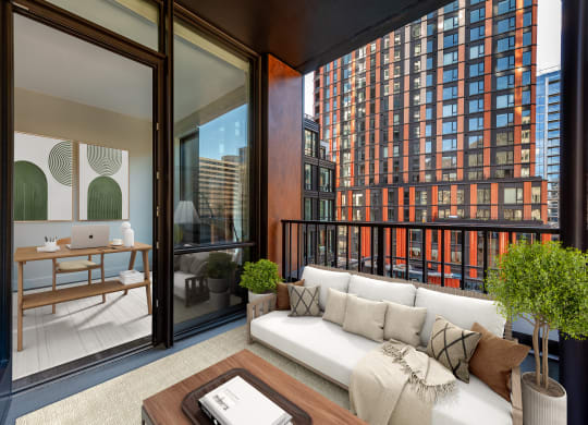 a living area with a couch and a desk in a balcony at The Grace and Reva, Arlington