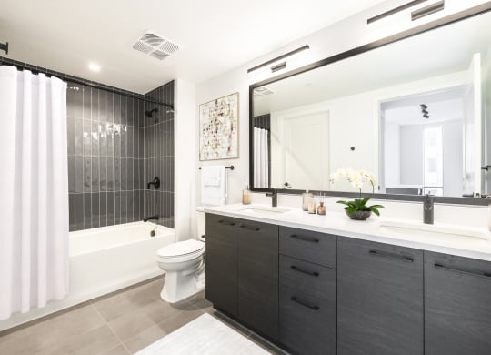 a bathroom with a large mirror and a shower and a toilet at The Grace and Reva, Arlington, VA