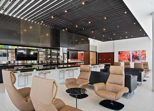 A modern lounge area with tan chairs and a black table.