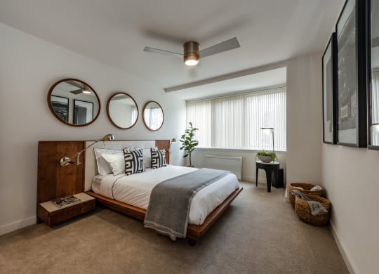 a bedroom with a bed and two mirrors on the wall