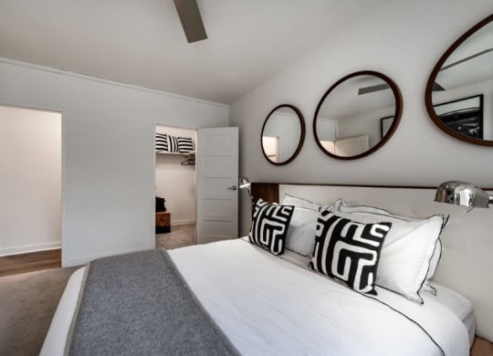 a bedroom with a bed and mirrors on the wall