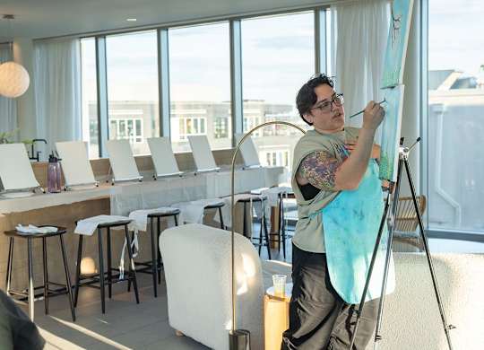 A man painting a picture at Spring Sip and Paint and 901W