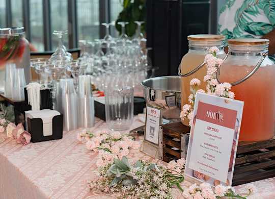 A table with a pink tablecloth and a Bar Menu at the 901W Rooftop and Rose event.