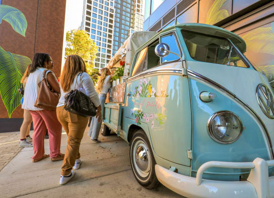 people standing next to a blue van parked on the street at The Grace and Reva, Arlington, Virginia