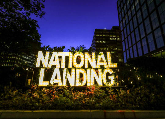 the sign for national landing at night at The Grace and Reva, Arlington, Virginia