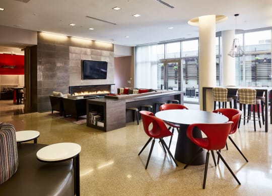 a lounge area with tables and chairs and a fireplace