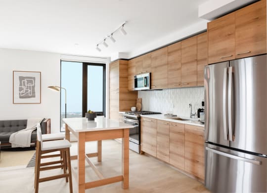 a kitchen with stainless steel appliances and a wooden table at The Grace and Reva, Arlington