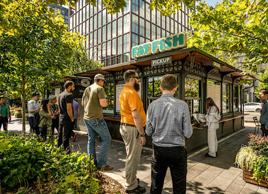 A group of people are standing in front of a food truck.