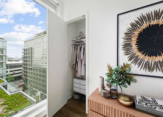 A room with a view of a green rooftop garden and a framed picture on the wall.