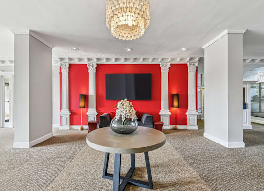 A large room with a round table and a chandelier hanging from the ceiling.