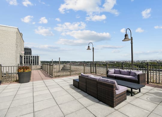 A patio with a couch, table, and lamp posts.