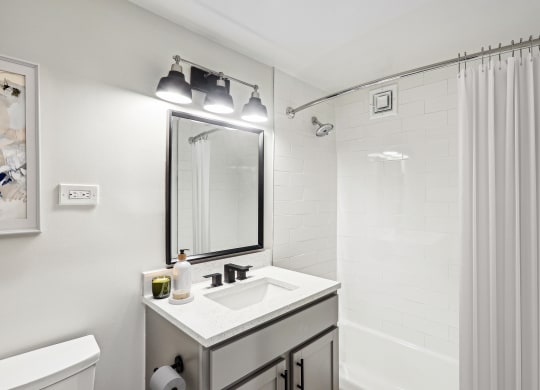 a bathroom with a sink and a shower and a mirror