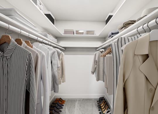 a walk in closet filled with clothes and shoes