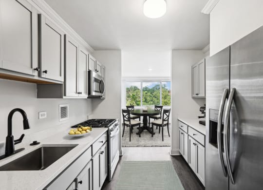 a kitchen with white cabinets and stainless steel appliances and a stainless steel refrigerator