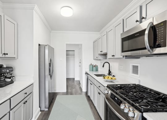 a white kitchen with stainless steel appliances and white cabinets