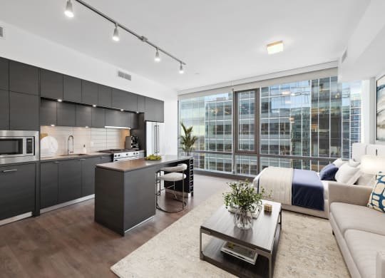 a living room with a kitchen and a bed