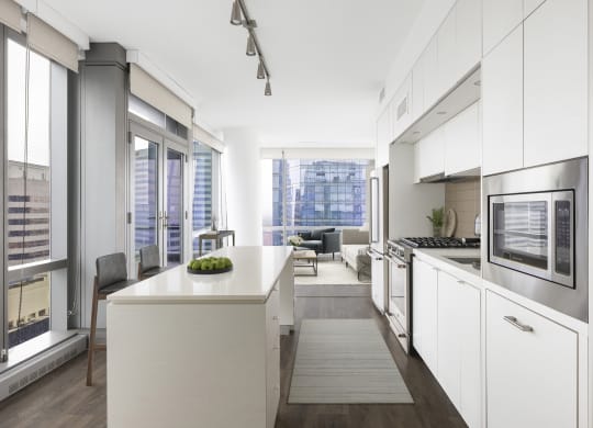 a kitchen with white cabinets and a white counter top and a living room