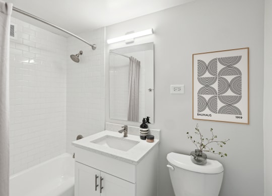 a bathroom with a toilet sink and shower and a mirror