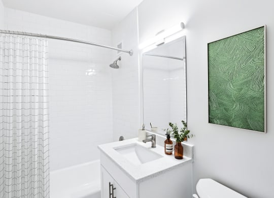 a white bathroom with a shower and a sink