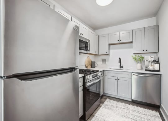 a white kitchen with stainless steel appliances and white cabinets