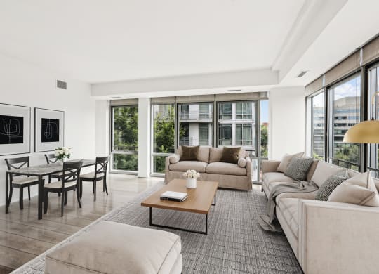 a living room with couches and a coffee table   and a dining table