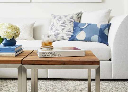 A book titled "Andy Warhol Polaroids 1958-1967" is on a coffee table in a living room.