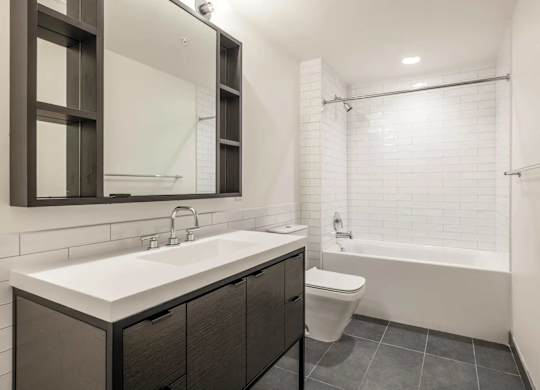 A modern bathroom with a white sink and a white toilet.