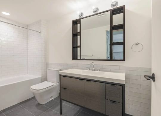 A white toilet sits next to a sink in a modern bathroom.
