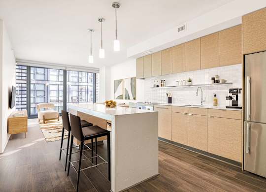 A modern kitchen with a white island and wooden cabinets.