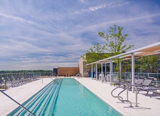 A large outdoor swimming pool with lounge chairs and a view of the horizon.