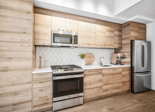 a kitchen with stainless steel appliances and wooden cabinets at The Grace and Reva, Arlington, Virginia