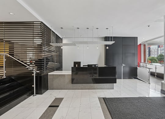 A black and white reception area with a black counter and a black and white rug.