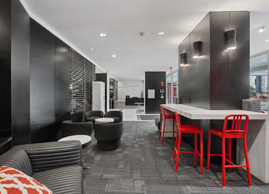 A black and red themed cafe with a long table and chairs.