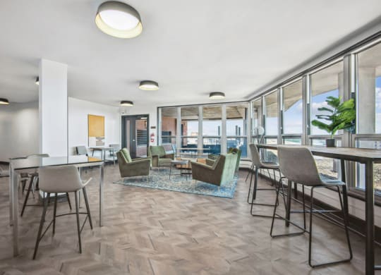 a living room with tables and chairs and a dining room with windows