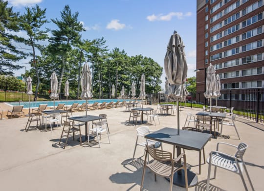 an outdoor patio area with tables and chairs and a swimming pool