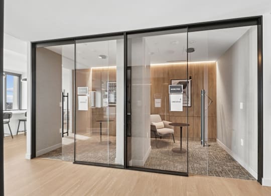 A glass door with a black frame separates two rooms.