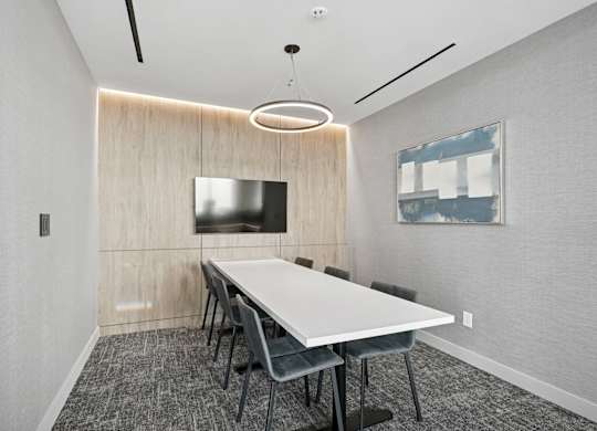 A conference room with a long table and chairs.
