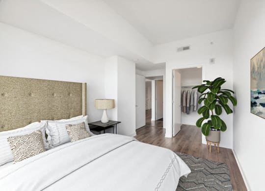 a bedroom with a bed and a potted plant