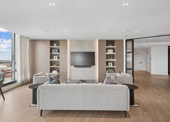 A modern living room with a grey sofa and a television.