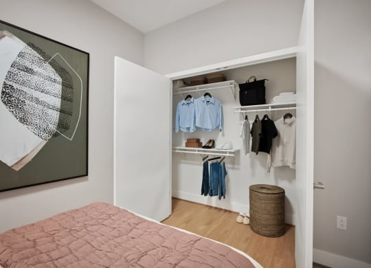 a bedroom with a large bed and a closet with clothes hanging on it at The Grace and Reva, Arlington, Virginia