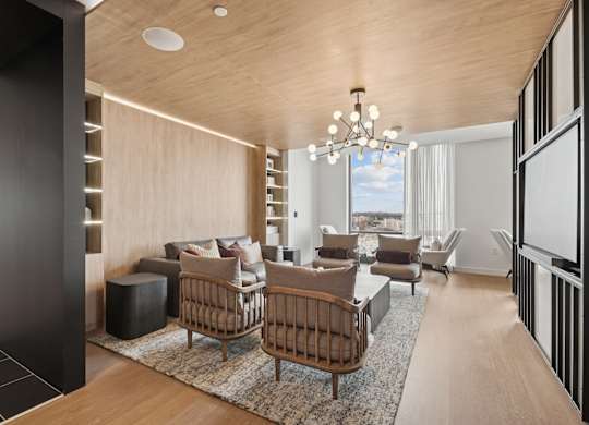A modern living room with a wooden ceiling and furniture.