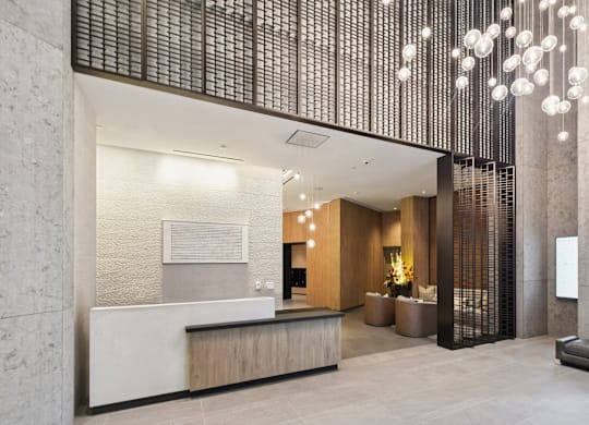 A reception area with a white counter and a brown bench.
