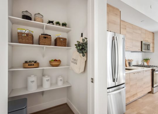 a kitchen with white shelves and a stainless steel refrigerator at The Grace and Reva, Virginia, 22202